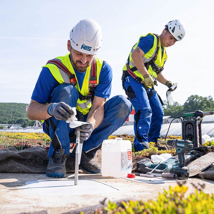 NIS Servicetechniker verbauen Monitoring-Module auf einem Industrieflachdach.jpg